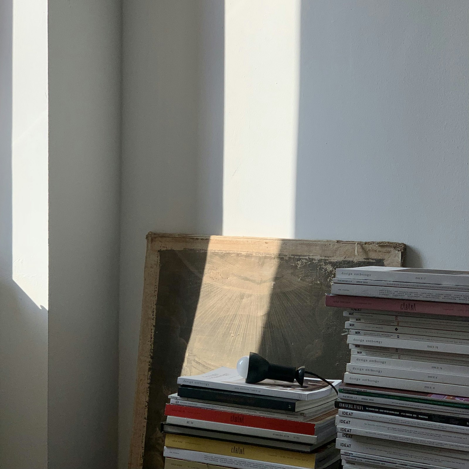晨光照進室內，牆邊堆疊的書冊